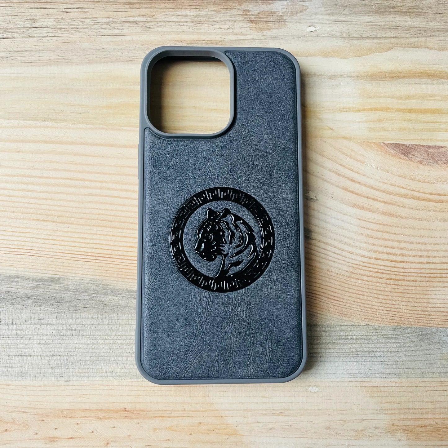 Gray Series | Premium Leather 3D Embossed iPhone  case with a tiger emblem on a wooden surface