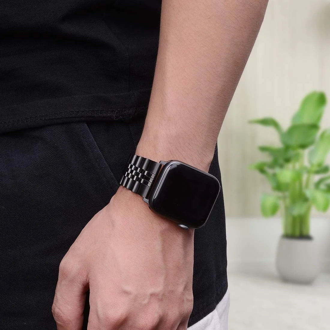 Black stainless steel Apple Watch band worn on wrist